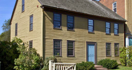 Image Of Two Yellow Houses And One White House Side-by-side. Each House Has A Brown Roof And Chimneys. 