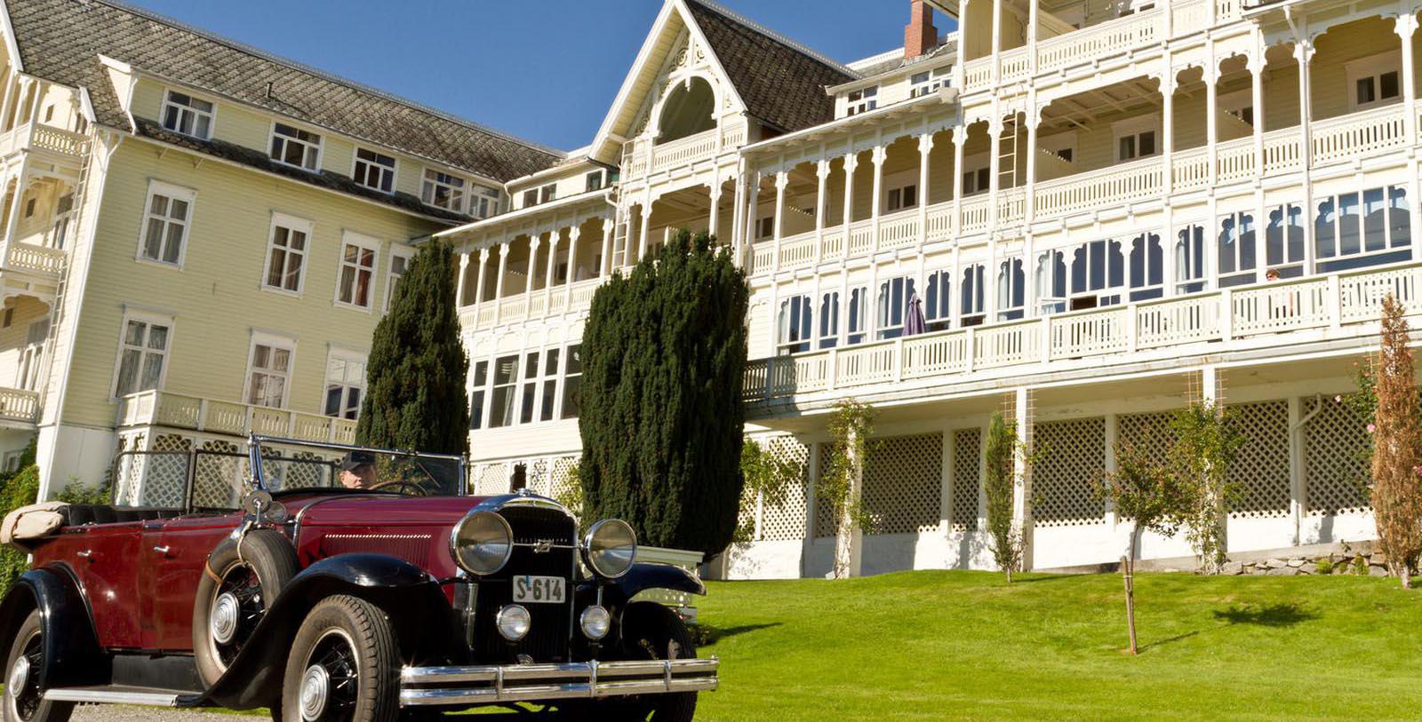 Image of Hotel Exterior with Historic Car Kviknes Hotel, 1752, Member of Historic Hotels Worldwide, in Balestrand, Norway, Special Offers, Discounted Rates, Families, Romantic Escape, Honeymoons, Anniversaries, Reunions